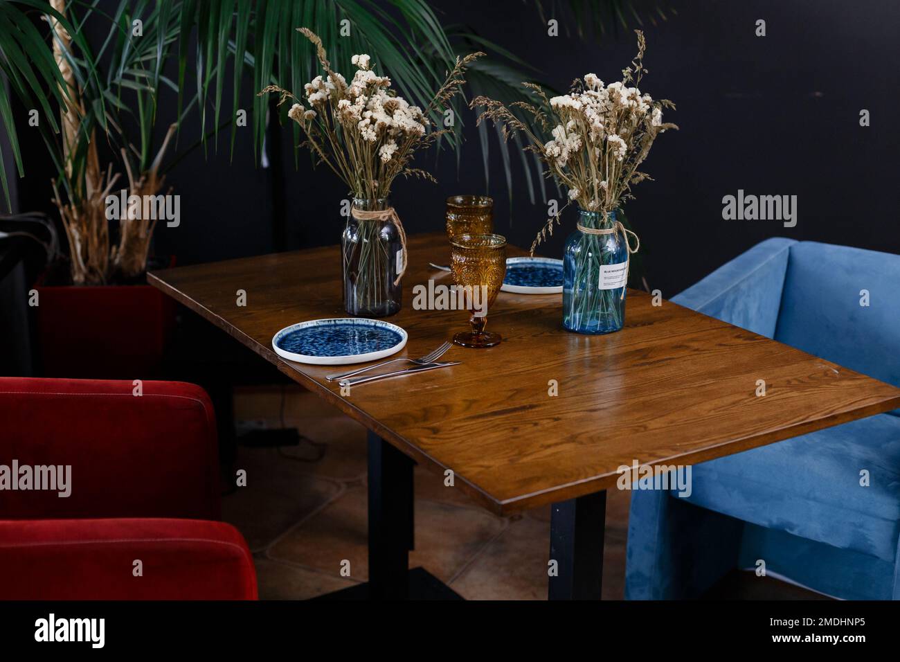 Künstliche Blumenvase auf dem Tisch über verschwommenem Bild des modernen Arbeitsplatzhintergrunds. Hochwertiges Foto Stockfoto