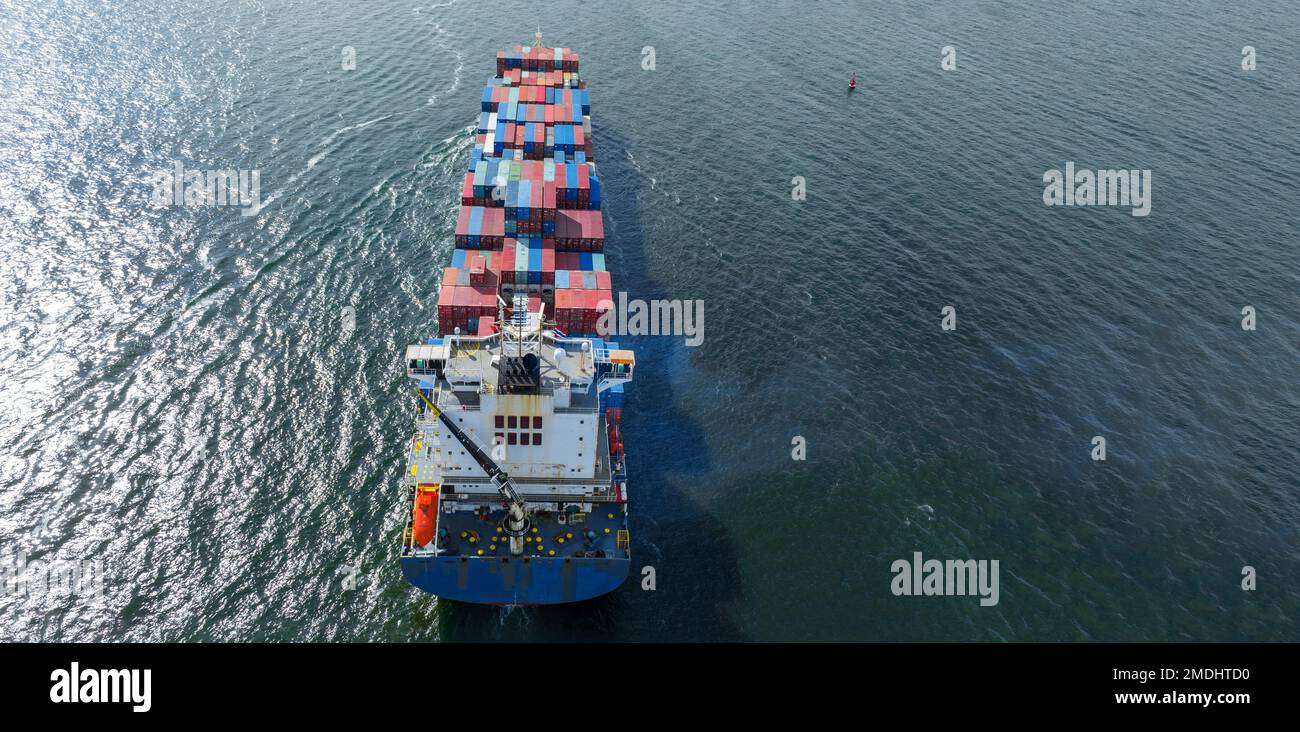 Frachtschiff mit Contrail im Seeschiff, das Container befördert und für die Exportkonzeptionstechnologie eingesetzt wird Güterbeförderung durch intelligente Schiffsdienste Stockfoto