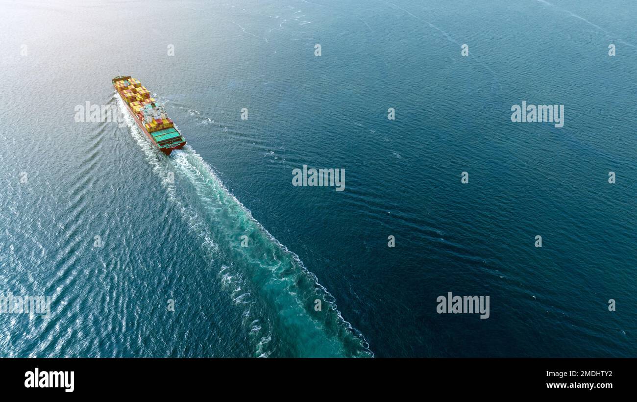 Frachtschiff mit Contrail im Seeschiff, das Container befördert und für die Exportkonzeptionstechnologie eingesetzt wird Güterbeförderung durch intelligente Schiffsdienste Stockfoto