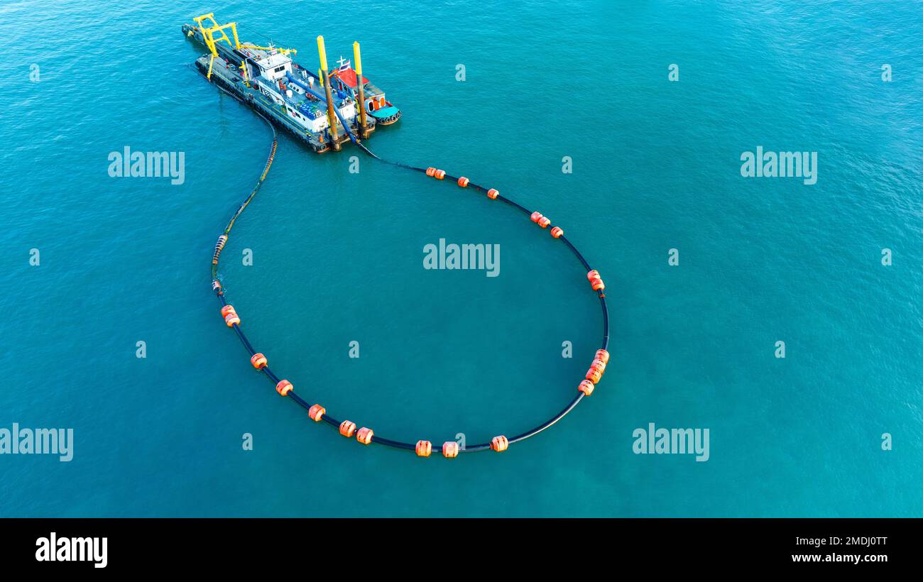 Die Schwimmsperre des Auslegers dient zur Eindämmung eines Ölauslaufs. Ein Offshore-Schiff, das im Meer Maßnahmen zur Bekämpfung von Ölunfällen durchführt. Stockfoto