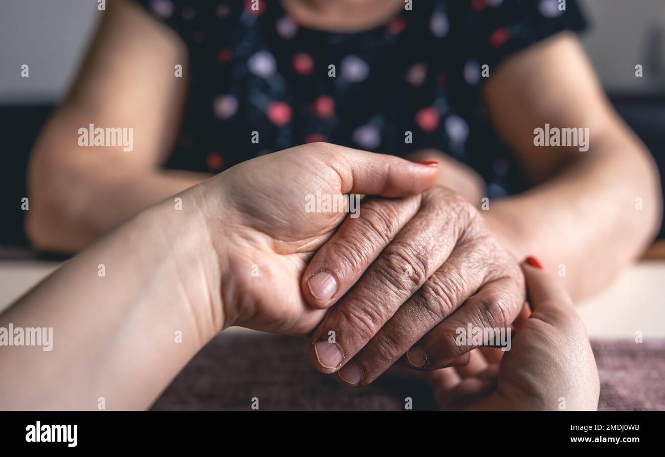 Ein alter und junger Mann, der Händchen hält, aus der Nähe. Stockfoto