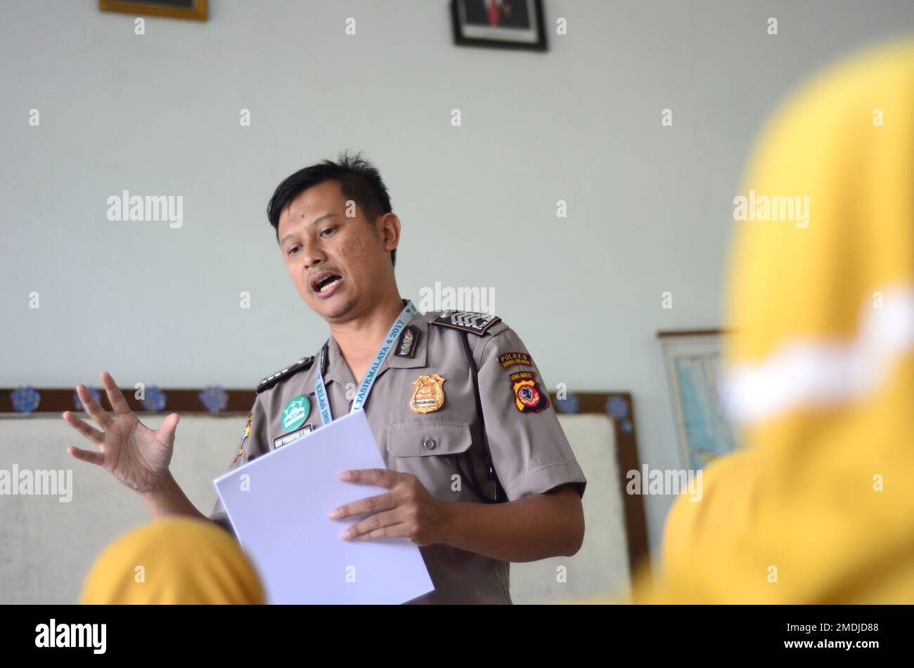 Ein Polizist unterrichtet einen schüler der Grundschule. Er erklärt seine Arbeit als Polizist, um den Schüler zu inspirieren. Stockfoto