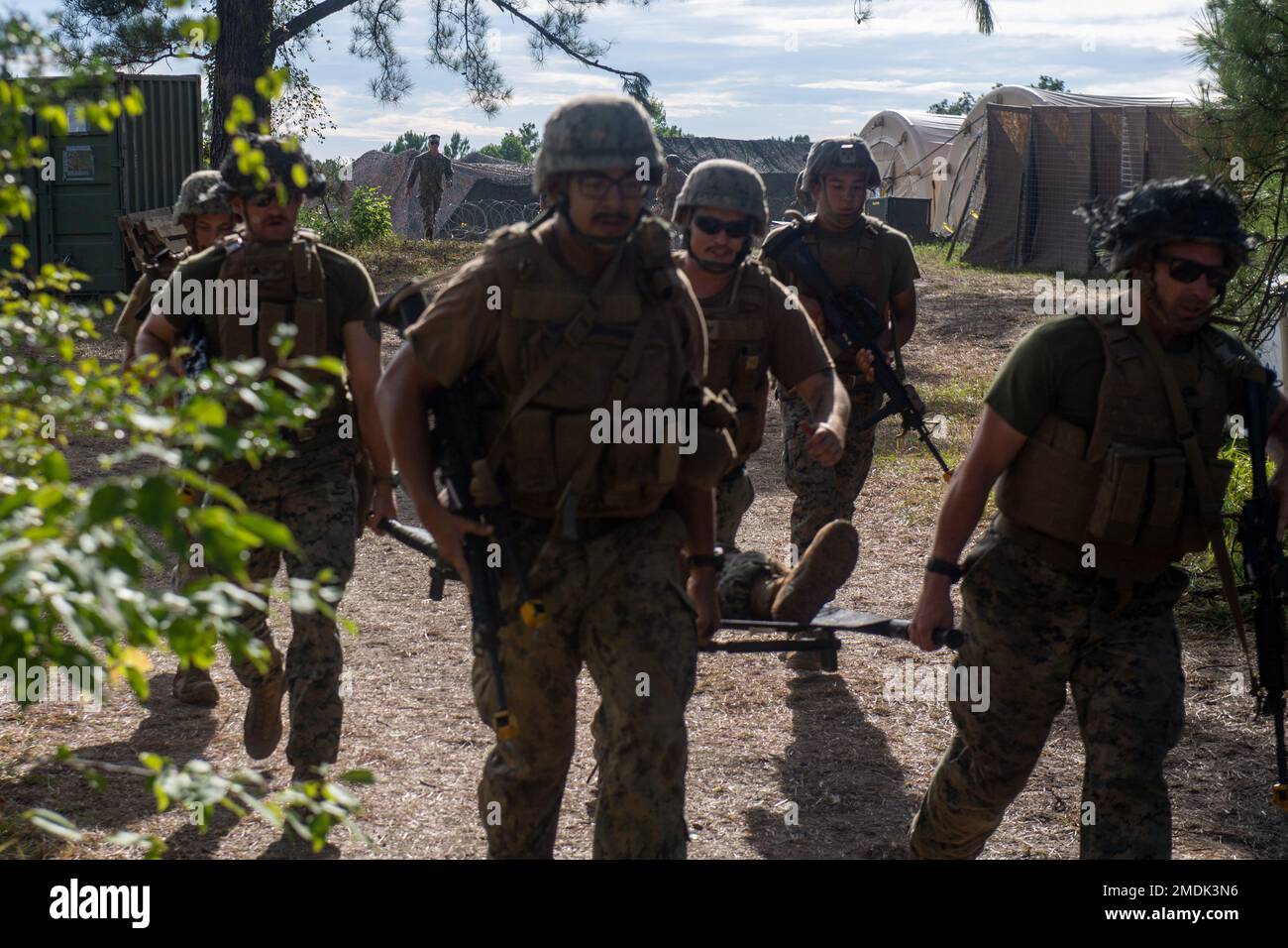 CAMP SHELBY, Miss. (25. Juli 2022) Seebäume, die dem mobilen Baubataillon der Marine (NMCB) zugeteilt wurden 1 Arbeiten mit Marines, die dem Stützschwadron der Marine Wing (MWSS) 273 zugeteilt wurden, um nach einem Angriff auf das Lager während der Operation Wendepunkt eine Trage zu tragen, auch bekannt als Feldübungsübung. Der Wendepunkt der Operation ist eine rund um die Uhr stattfindende Übung, bei der der Schwerpunkt auf dem Aufbau fortschrittlicher Grundlagen liegt, während gleichzeitig die Fähigkeit zur Taktik und Überlebensfähigkeit gewahrt bleibt. NMCB 1 wird aus Gulfport Homeportiert, Miss. Sie führen ein intensives Homeport-Training durch, um ihre Fähigkeit zu erweitern, Konstruktionen auszuführen Stockfoto