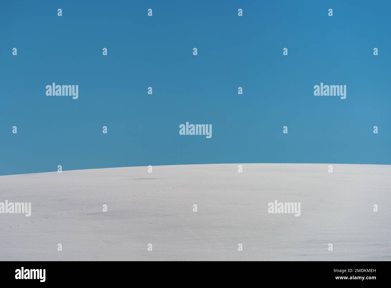 Abstrakte minimalistische Winterlandschaft, schneebedeckter Hügel mit blauem Himmel im Hintergrund an sonnigen Tagen, Kopierbereich im Preis inbegriffen Stockfoto