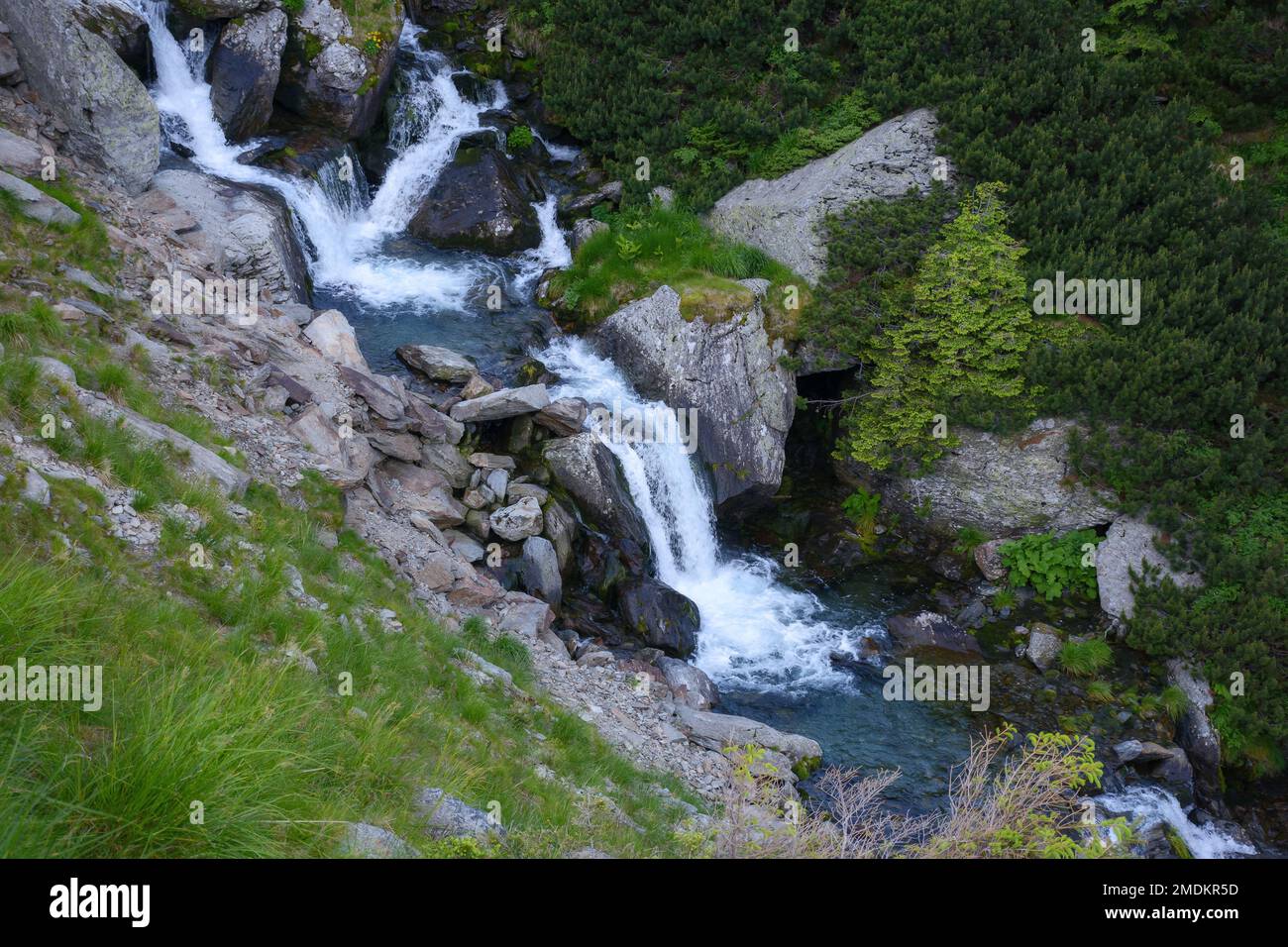 Landschaft mit Fluss. Bäume und Steine entlang der Küste den Hügel hinunter. Blick von oben Stockfoto