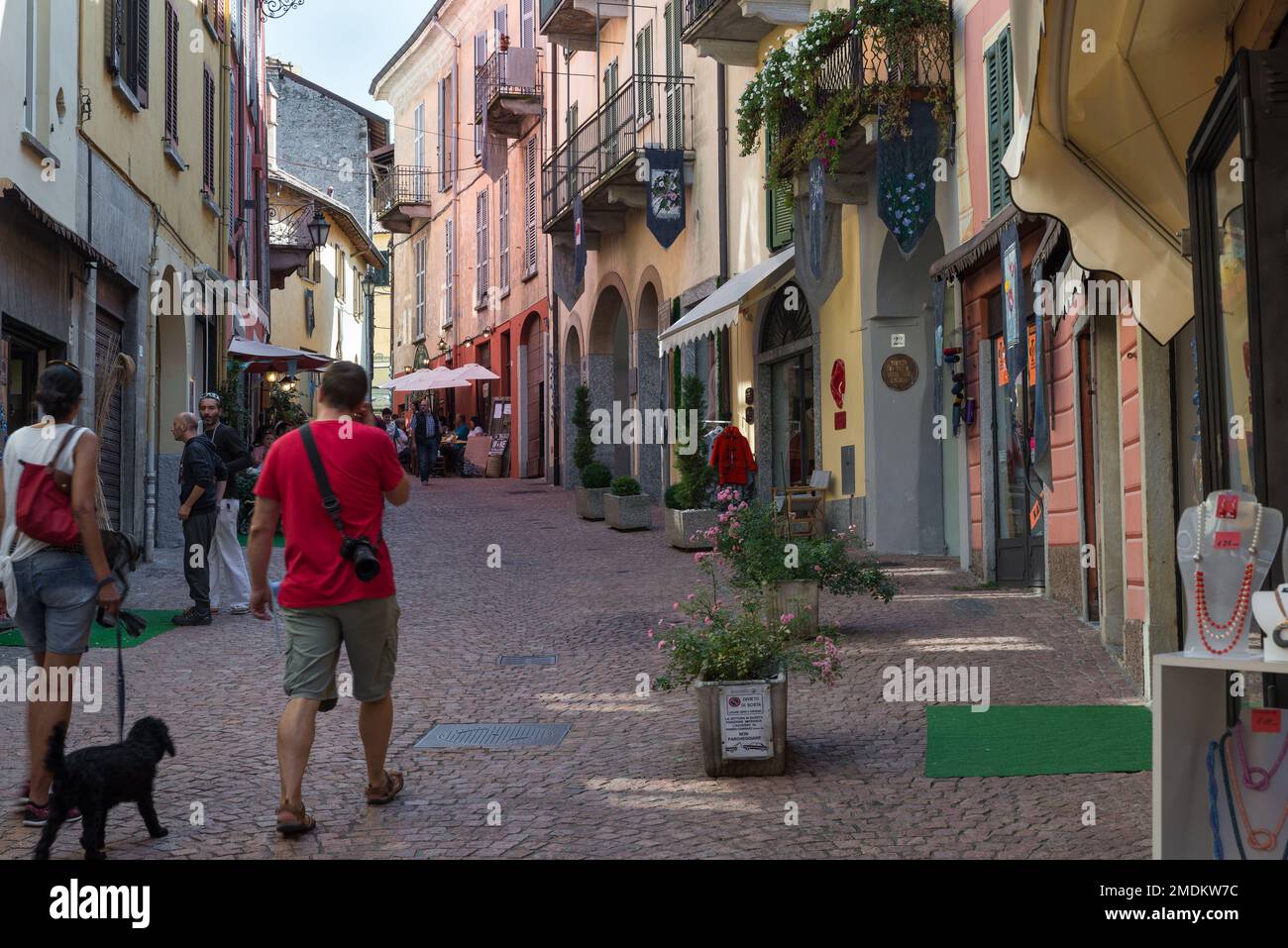 Malerische Kopfsteinpflastergasse mit traditionellen Restaurants, Luino, Italien Stockfoto