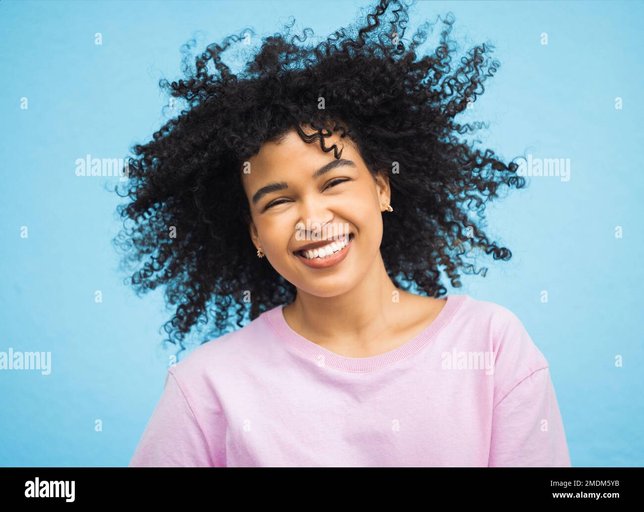 Schütteln Sie Haare, ein glückliches Gesichtsbild und eine schwarze Frau mit gesundem Shampoo-Haarstil, Studioschönheit oder Gesichtspflege. Kosmetik-Make-up, Spa-Salon und Afro Stockfoto