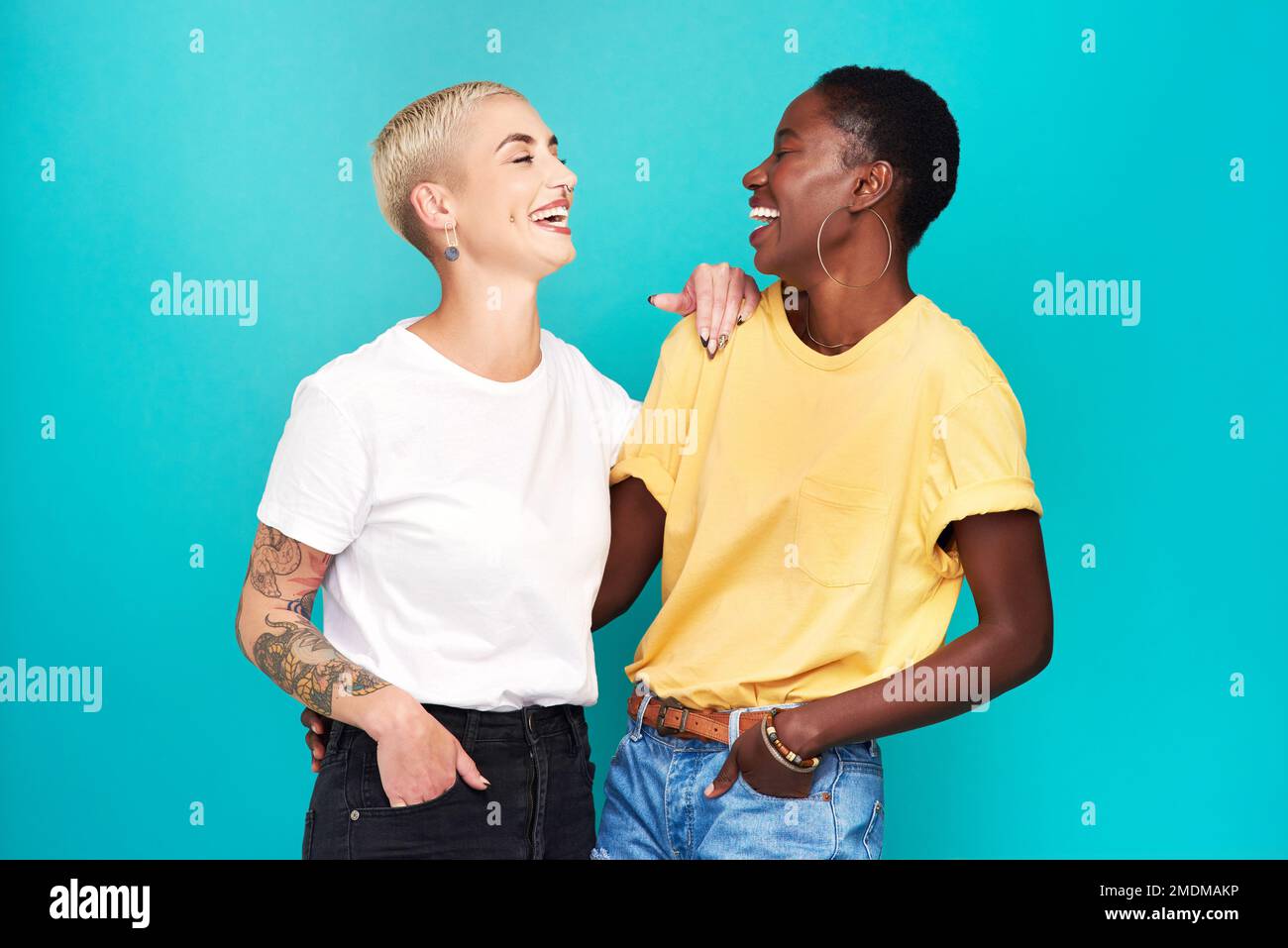 Es gibt keine bessere Bindung als diese beste Freundschaft. Studioaufnahme von zwei glücklichen jungen Frauen, die sich vor türkisfarbenem Hintergrund posieren. Stockfoto
