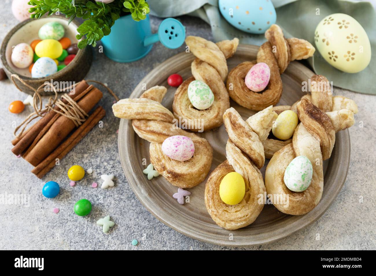 Osterhasen-förmige Brötchen pusten Gebäck mit Zimt auf einem Steintisch. Osterbackidee. Stockfoto