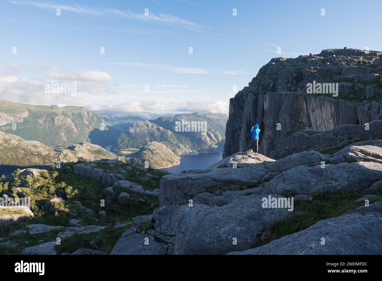 In der Nähe von Preikestolen (Pulpit Rock), der berühmten Touristenattraktion in Ryfylke, die über dem Lysefjord thront. Der Typ auf dem Felsen macht Bilder der Natur auf dem Stockfoto
