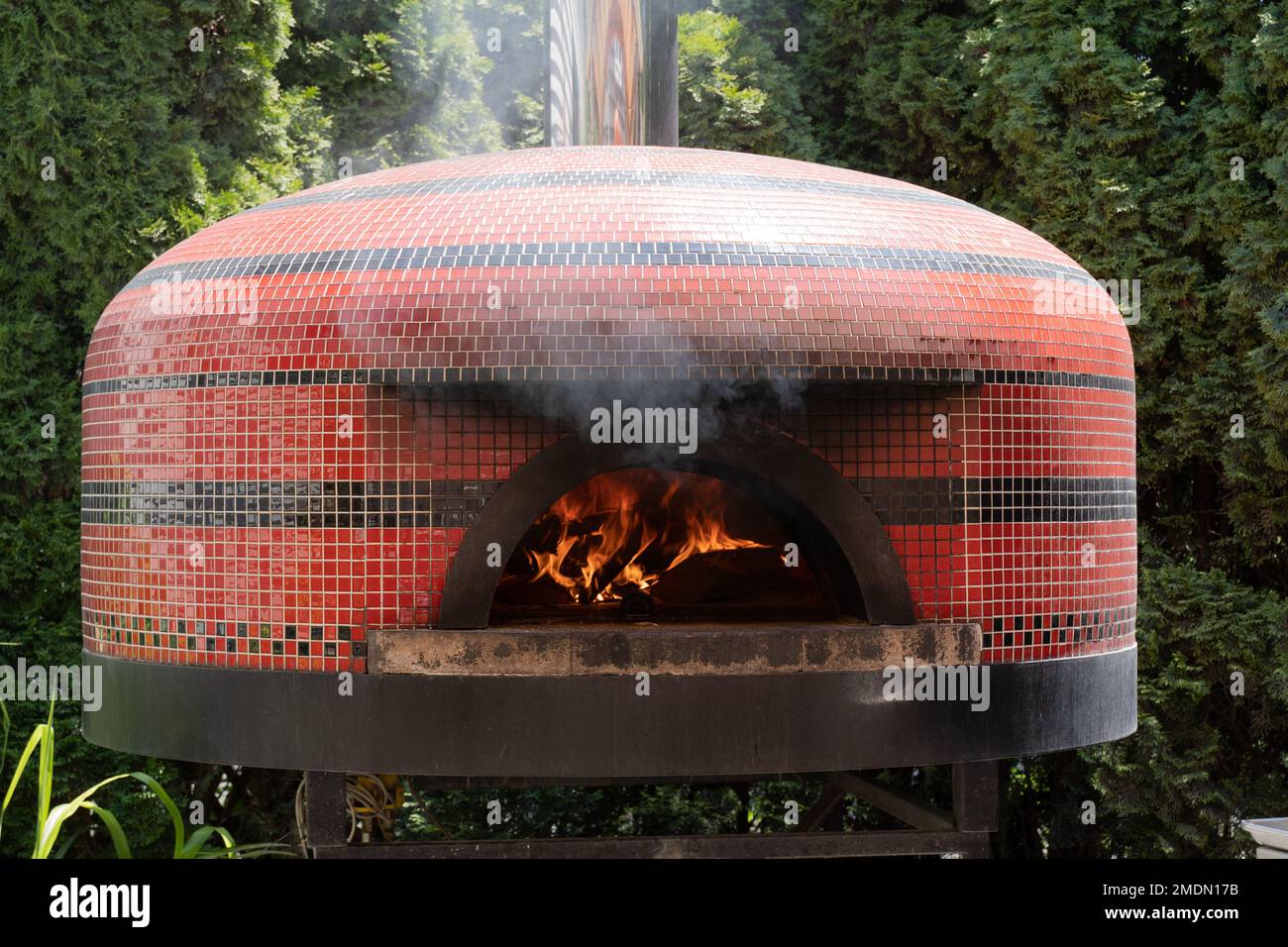 Dieser Pizzaofen im Freien mit Holzfeuer, der den Herd erwärmt, war in einem kleinen Restaurant in der kleinen Stadt Cape Cod von Sandwich Stockfoto