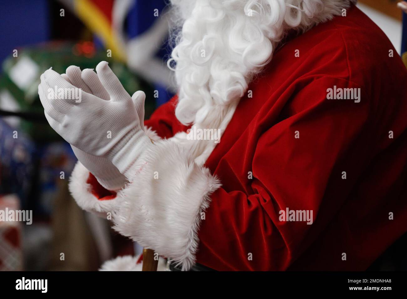 Schwache Tiefenschärfe (selektive Fokussierung) Details mit dem Weihnachtsmannkostüm eines Mannes während einer Kinderweihnachtsfeier. Stockfoto