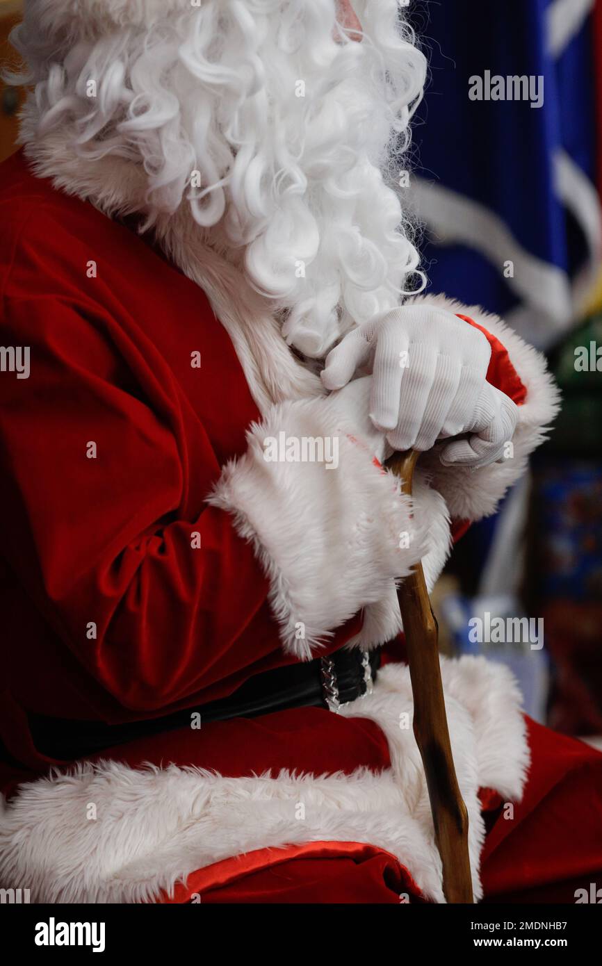 Schwache Tiefenschärfe (selektive Fokussierung) Details mit dem Weihnachtsmannkostüm eines Mannes während einer Kinderweihnachtsfeier. Stockfoto