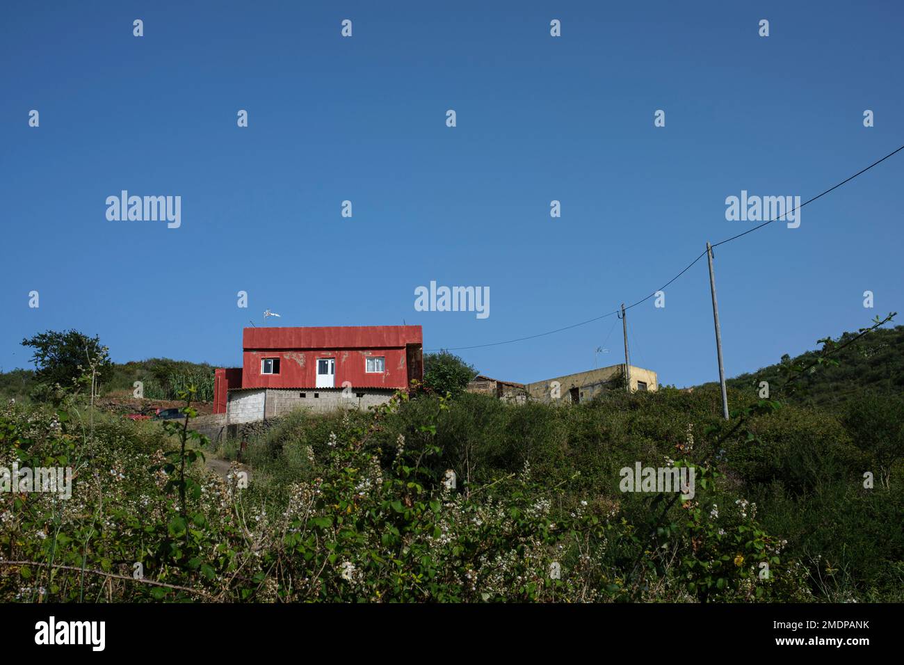 Rustikales, rot gestrichenes Bauernhaus vor blauem Himmel in Erjos, Teneriffa, Kanarische Inseln, Spanien Stockfoto