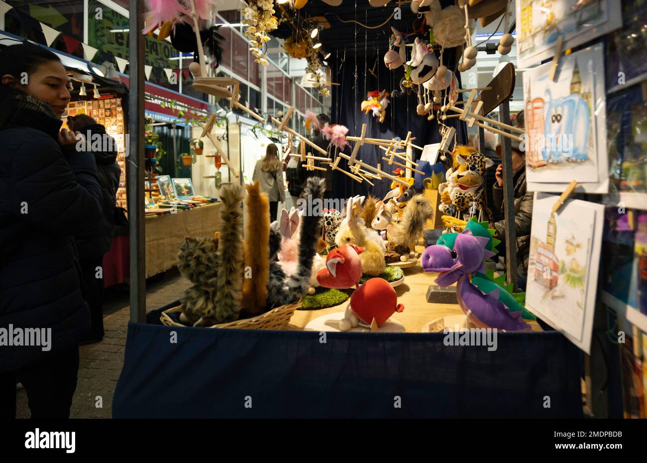 London - 02 27 2022: Frau auf dem Covent Garden Markt vor einem Spielzeugstand Stockfoto