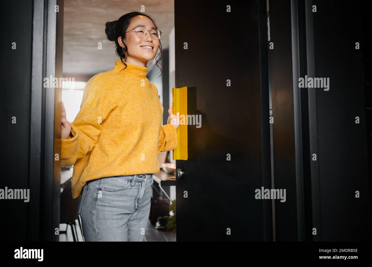 Eine kreative und asiatische Frau, die eine Tür zu einem Büro in einem Startup-Unternehmen für Grafikdesign öffnet. Vision, glücklicher und japanischer Designer an einem Arbeitsplatz Stockfoto
