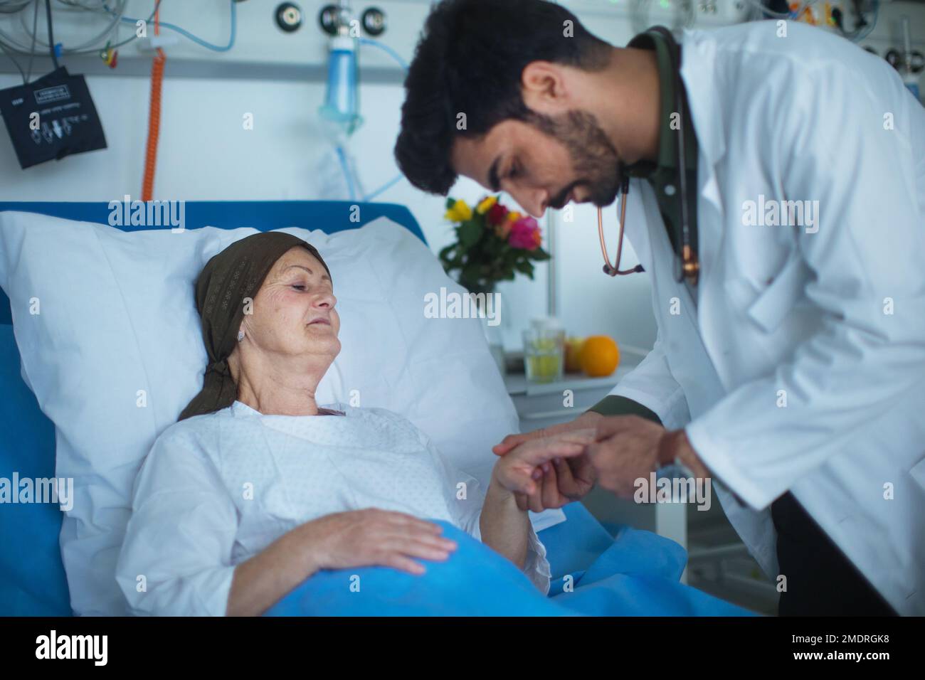 Junger Arzt aus dem Nahen Osten, der Krebspatienten im Krankenhaus untersucht. Stockfoto
