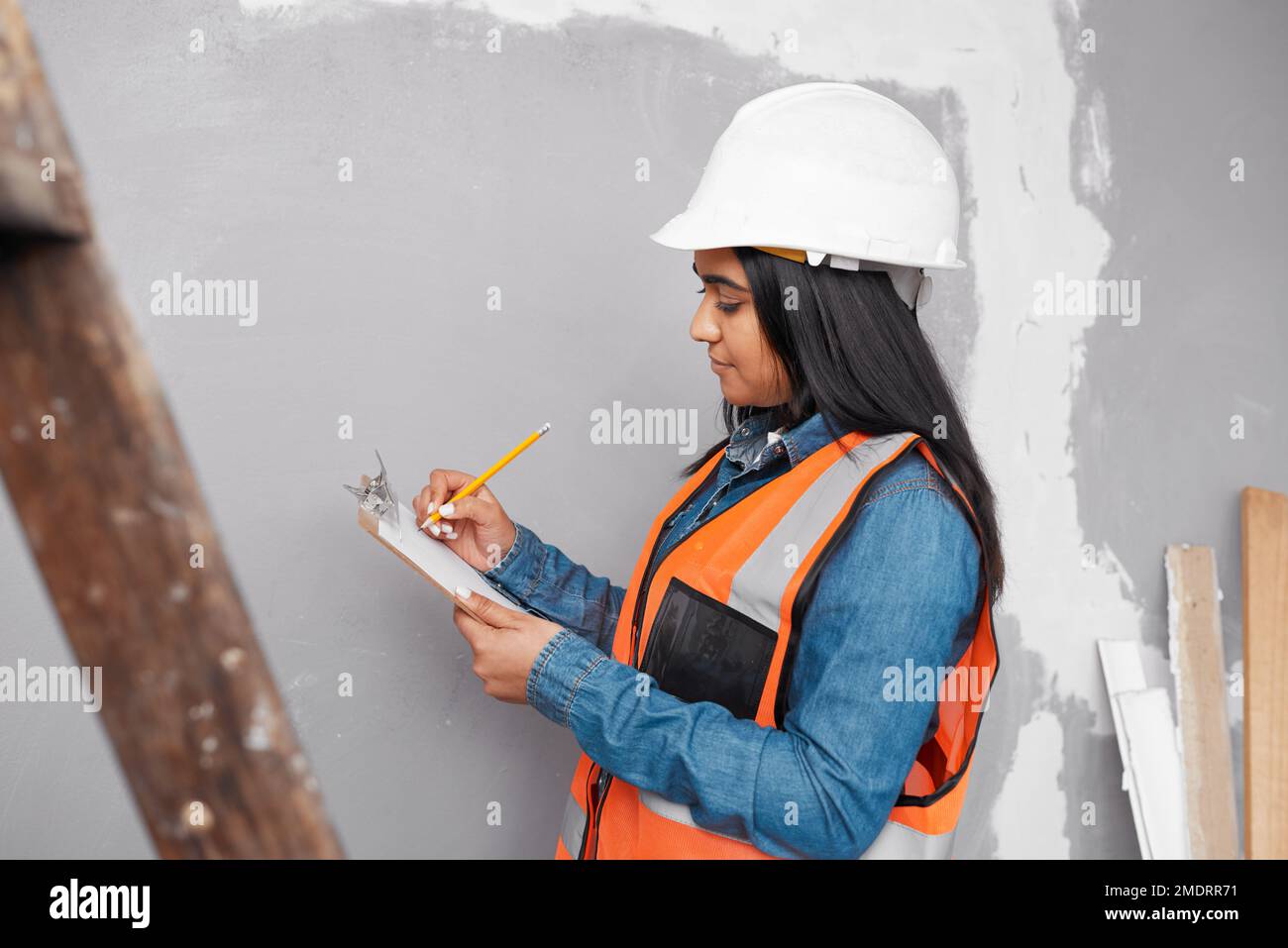 Ein Bauleiter überprüft das Renovierungsprojekt mit einer Checkliste auf der Zwischenablage Stockfoto