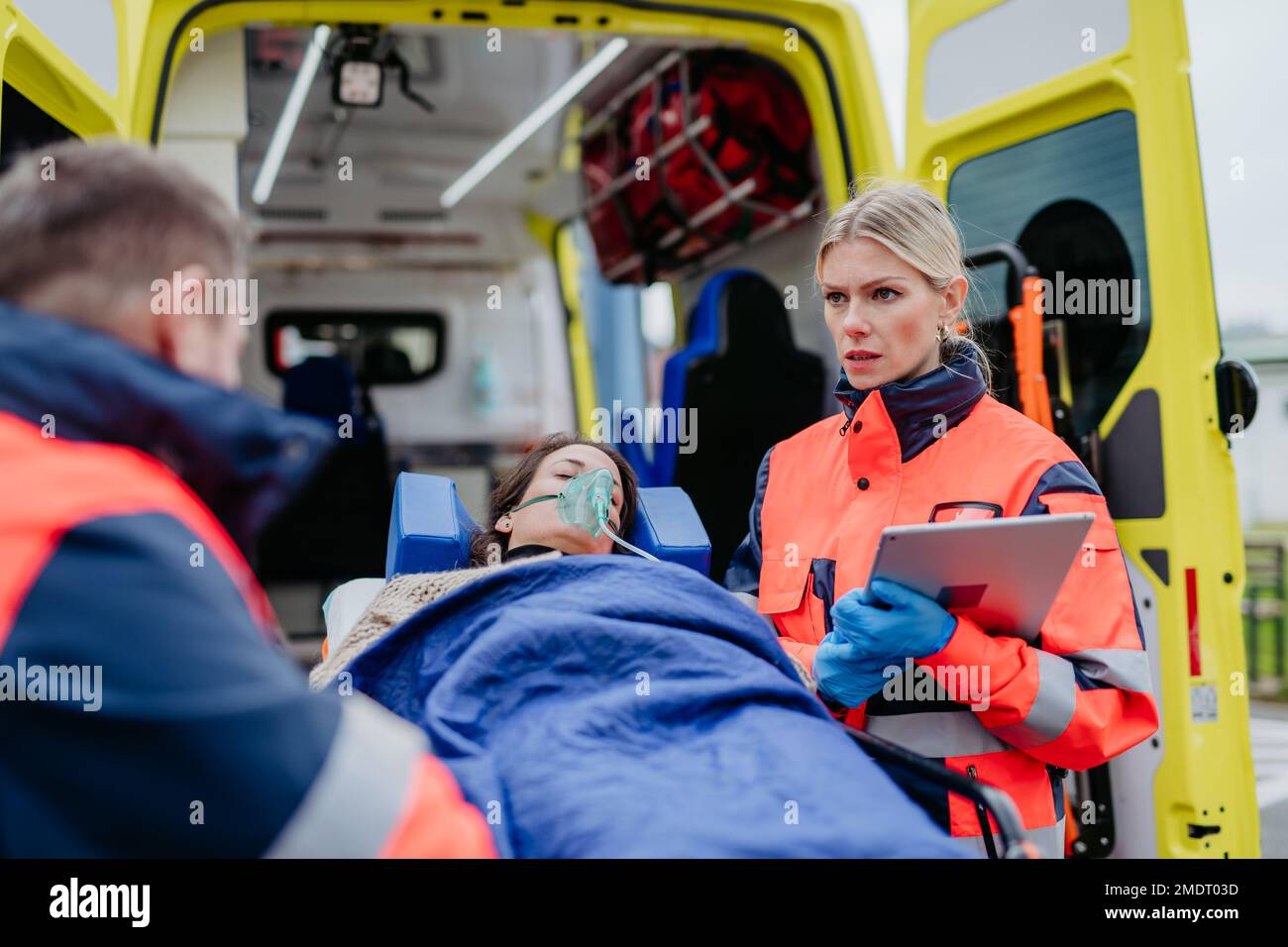 Rettungskräfte kümmern sich um die Patientin und bereiten sie auf den Transport vor. Stockfoto