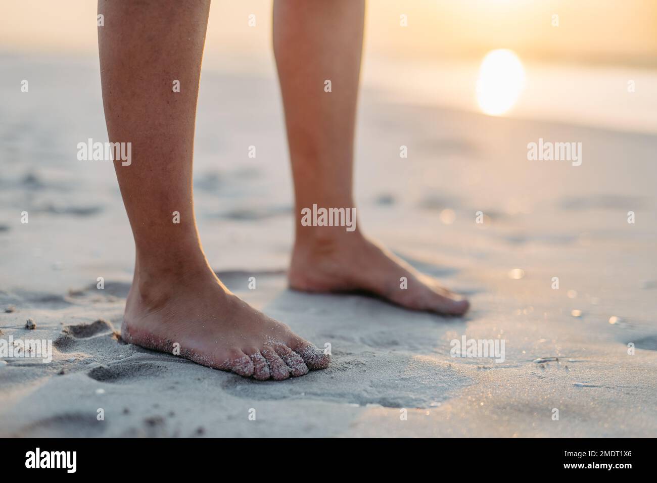 Nahaufnahme von Frauen Füße im Sand, auf See. Stockfoto