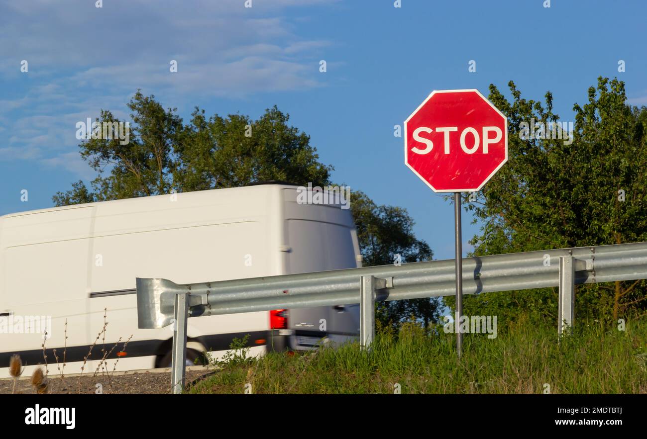 Rotes Stoppschild mit blauem Himmel und Wolken Hintergrund der Straße. Stockfoto