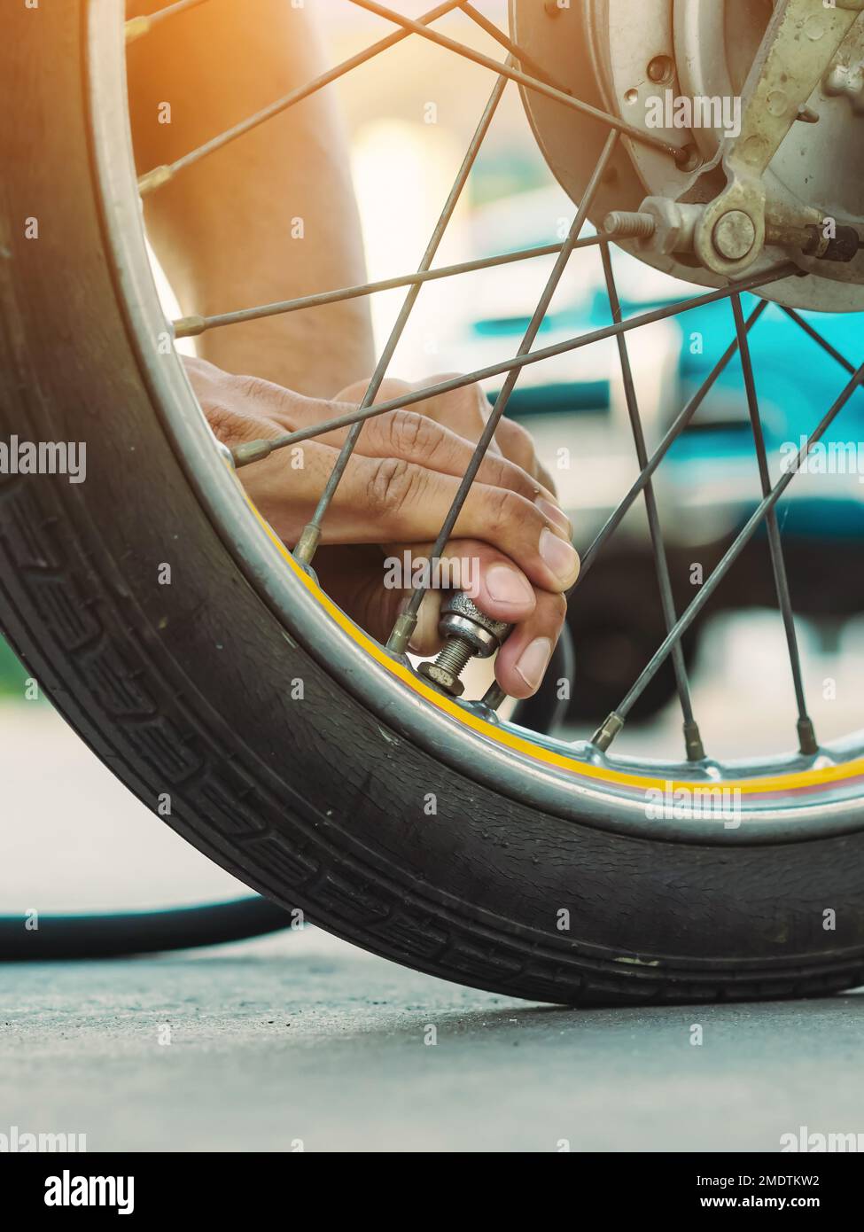 Die Hand eines Mannes prüft den Druck im Gasgenerator und pumpt einen Reifen auf einem Motorrad mit einem Luftkompressor auf. Mann, der den Luftdruck prüft und den Reifendruck auffüllt Stockfoto