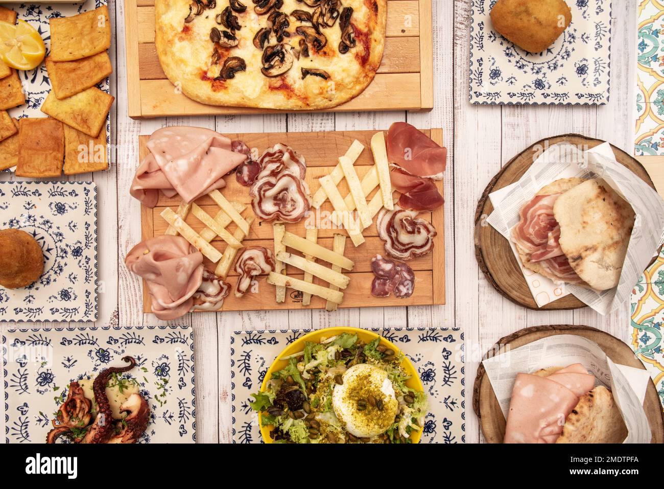 Auswahl an Gerichten der typisch italienischen Küche mit einem hölzernen Zentrum mit Antipasto Stockfoto