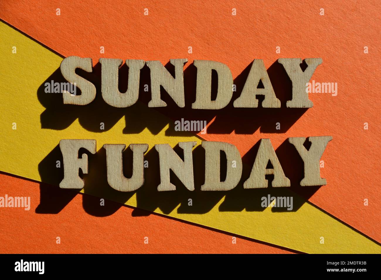 Sonntagsfunk, Wörter in hölzernen Buchstaben isoliert auf hellem gelben und orangefarbenen Hintergrund Stockfoto