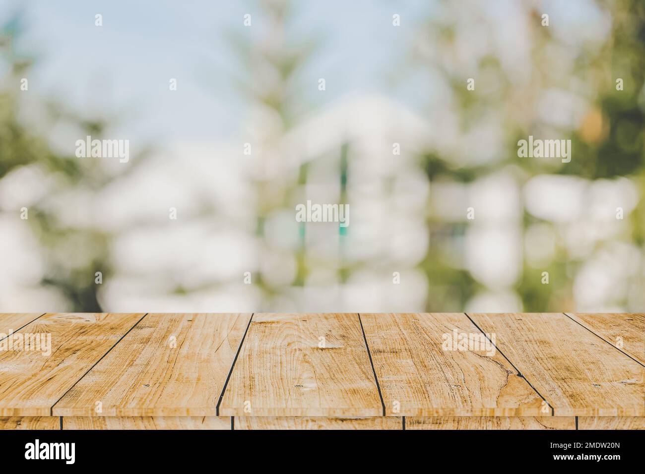 Holztisch mit grünem Garten Unschärfe-Hintergrund im Außenbereich für Werbemontagevorlage Stockfoto