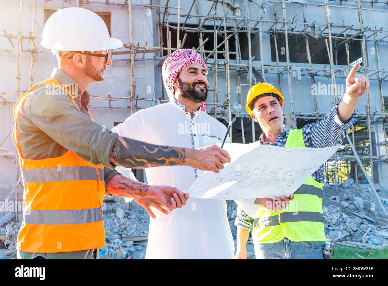Die Gruppe des Ingenieurteams mit dem Projektmanager des arabischen Gewerbegebiets prüft den Grundriss des Gebäudes auf der Baustelle Stockfoto