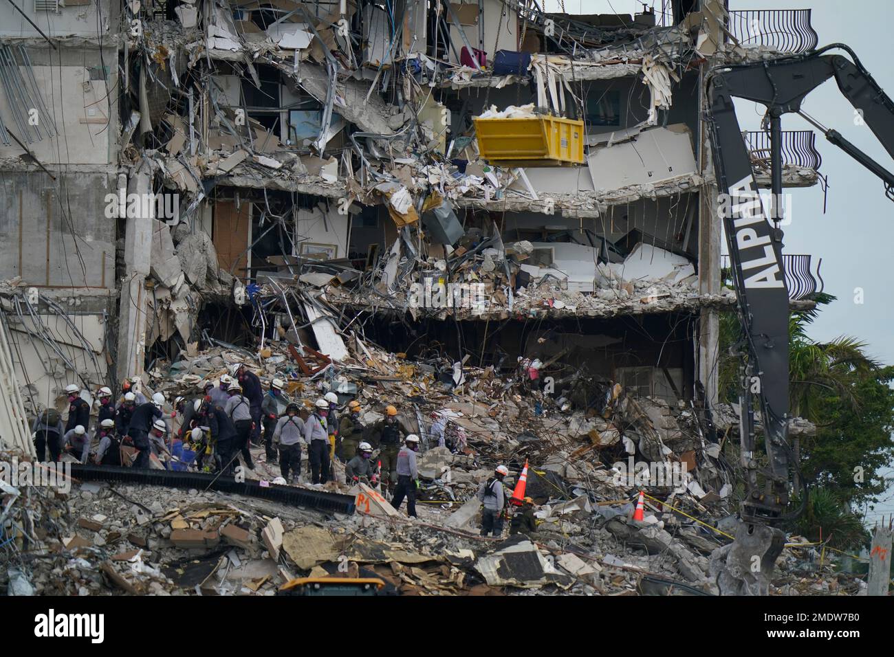 Search and rescue personnel work atop the rubble at the Champlain