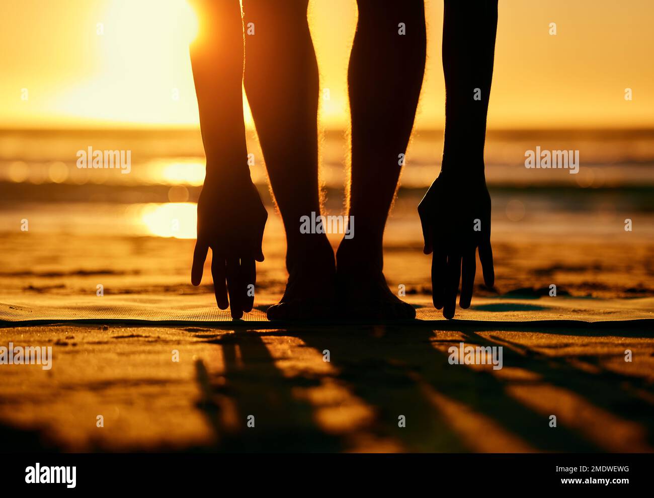 Silhouette, Sonnenaufgang und Yoga mit Fitness, Stretching am Strand und Körpertraining, Zen mit Natur. Person Beine, Hände und Modell, Ozean mit Stockfoto
