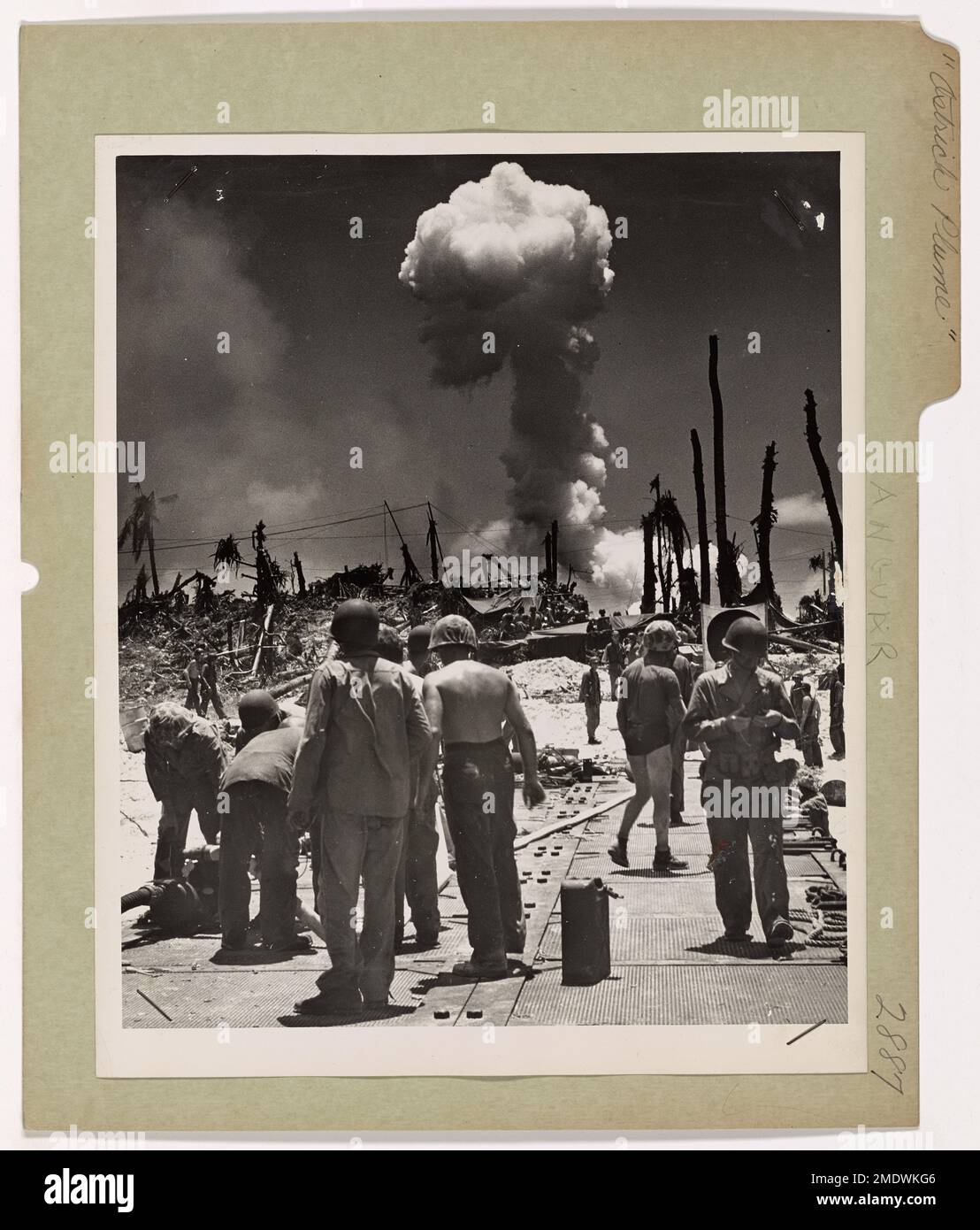 Von einer brennenden Munitionslade in der Nähe des Strandes von Angaur Island strömt Rauch in den Himmel. Küstenwache und Soldaten arbeiten daran, die Flamme auf einem hastig gebauten Pontondamm während der Schlacht um Angaur, einem Teil der Palau-Inseln-Kampagne, zu löschen. Stockfoto