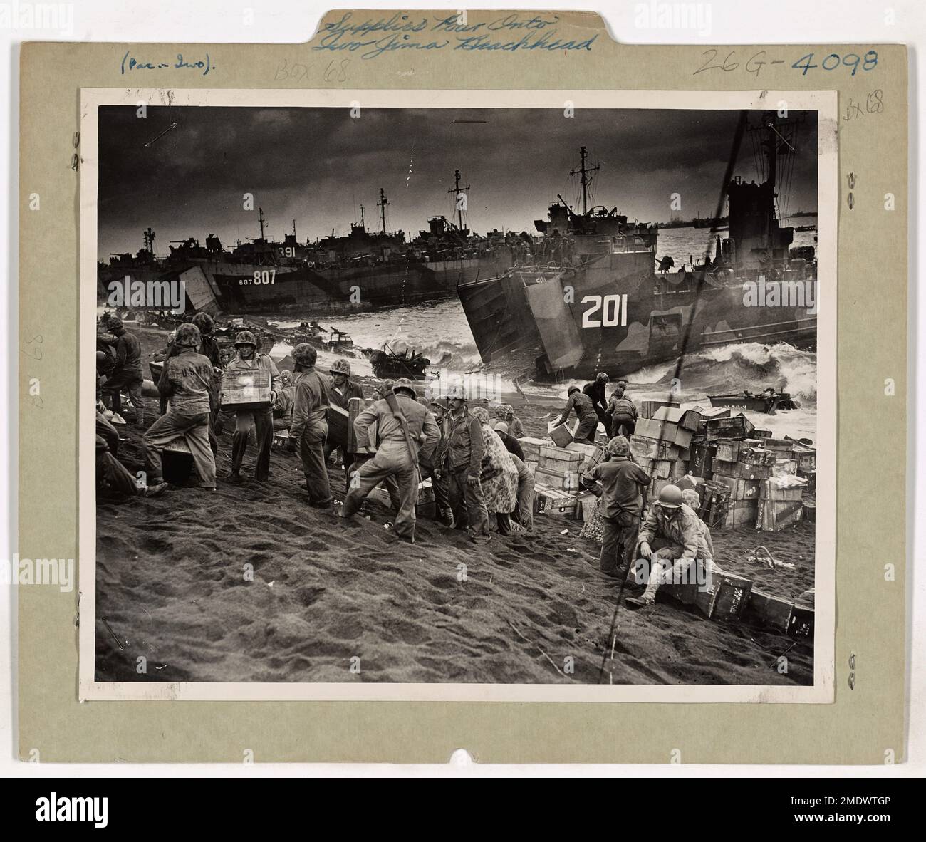 Dieses Bild zeigt den intensiven Fluss von Vorräten, der kurz nachdem die Marines ihre Position gesichert hatten, auf den Strand von Iwo Jima entladen wurde. Der Fluss von militärischer Ausrüstung und Material war für die Unterstützung der amerikanischen Streitkräfte während der anhaltenden Schlacht um die Insel von entscheidender Bedeutung. Stockfoto
