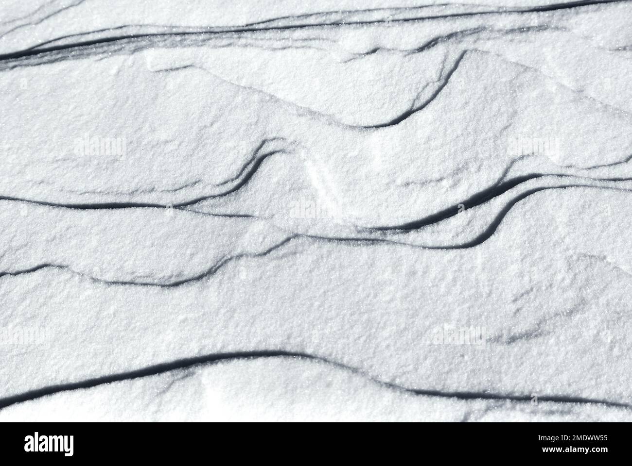 Weißer Schnee mit natürlich erzeugter Textur, Form und Muster als Hintergrund im Winter. Stockfoto