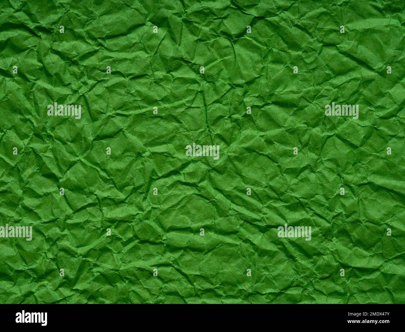 Hellgrüne, matte, zerknitterte Papierstruktur. Hintergrund für Kunsthandwerk, St. Patrick's Day, Neujahrsdesigns Dekoration, Text, Schriftzug, Wandbildschirm Stockfoto