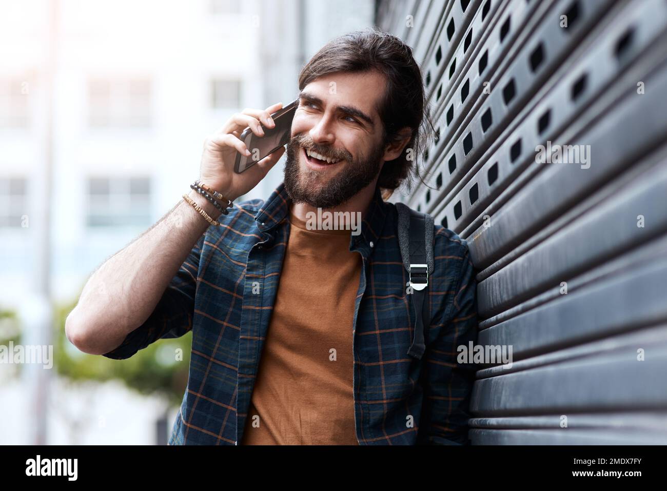 Genau das wollte ich hören. Ein gutaussehender junger Mann, der sein Handy benutzte, während er in der Stadt spazierte. Stockfoto