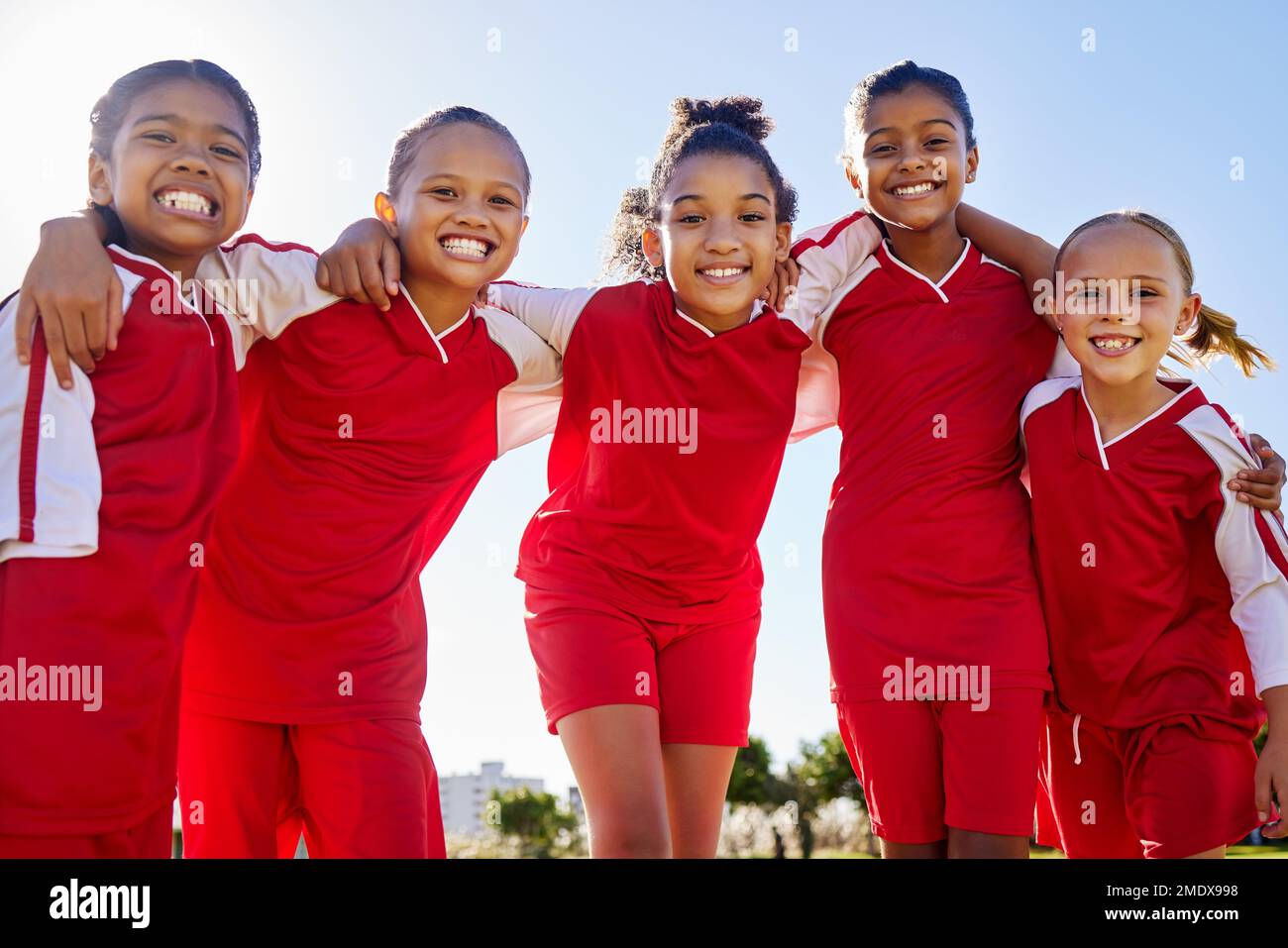 Football Girl, Gruppenporträt und Feld für Lächeln, Teambildung Glück und Solidarität beim Sporttraining. Weibliche Kinder, sportliche Vielfalt und Freunde Stockfoto