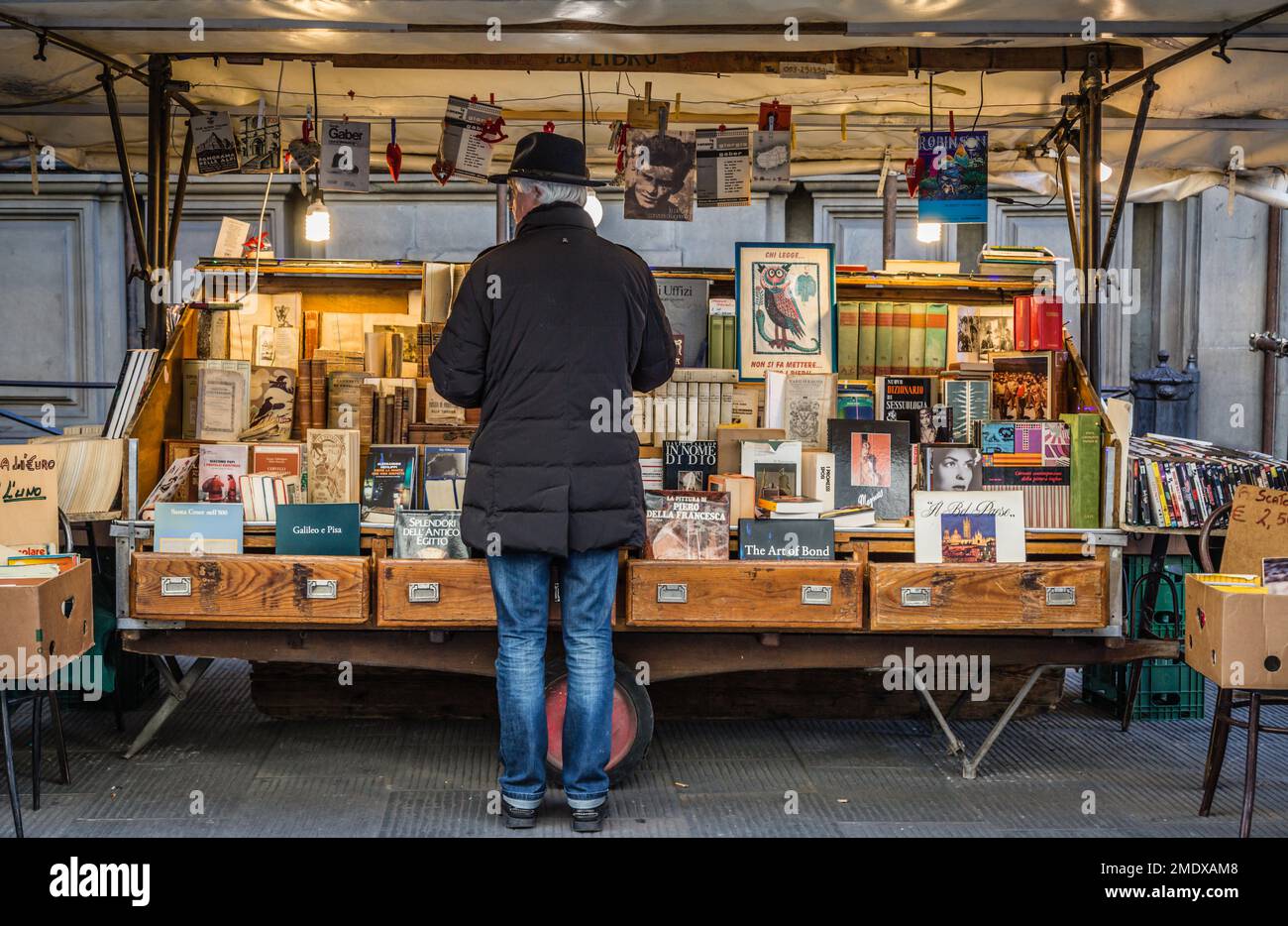 Ein Mann, der im Winter in Florenz, der Toskana, Italien, Bücher am Buchstand im Freien einkauft. Stockfoto
