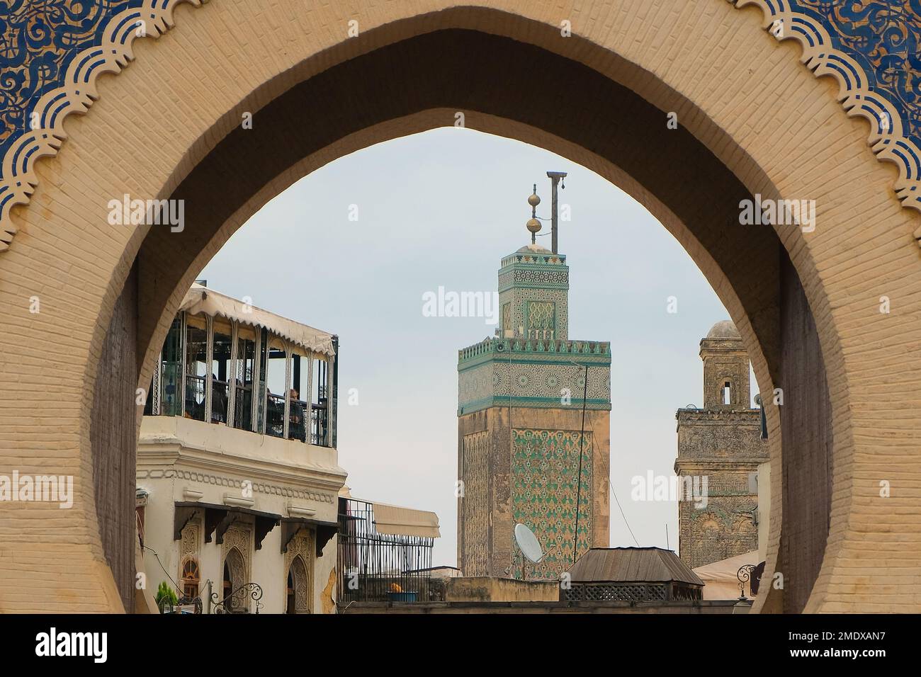 Fez, Marokko - Minarette von Marinid Bou Inania Madrasa durch das Stadttor von Bab Bou Jeloud. Monumentaler französischer Eingang in der alten Medina von Fez el Bali. Stockfoto