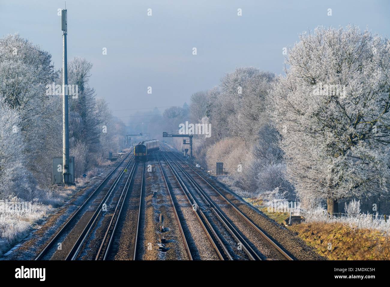 Zug auf Bahngleisen am Wintertag Stockfoto