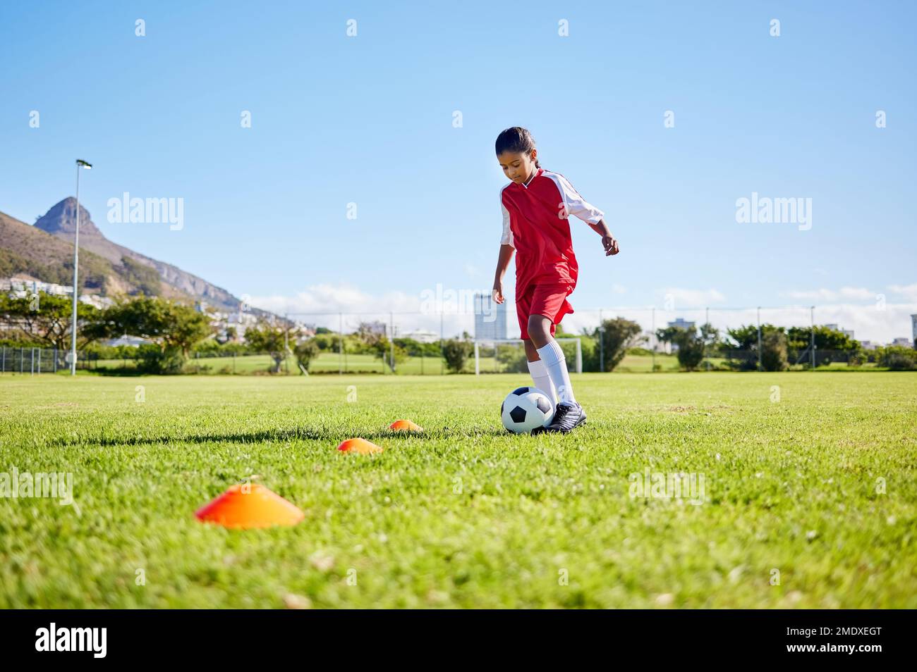 Fußball-Mädchen, Training und Gras für Fitness, Schnelligkeit oder Balance mit sportlicher Talententwicklung, Kontrolle und Schnelligkeit. Weibliches Kind, schneller Fußball Stockfoto