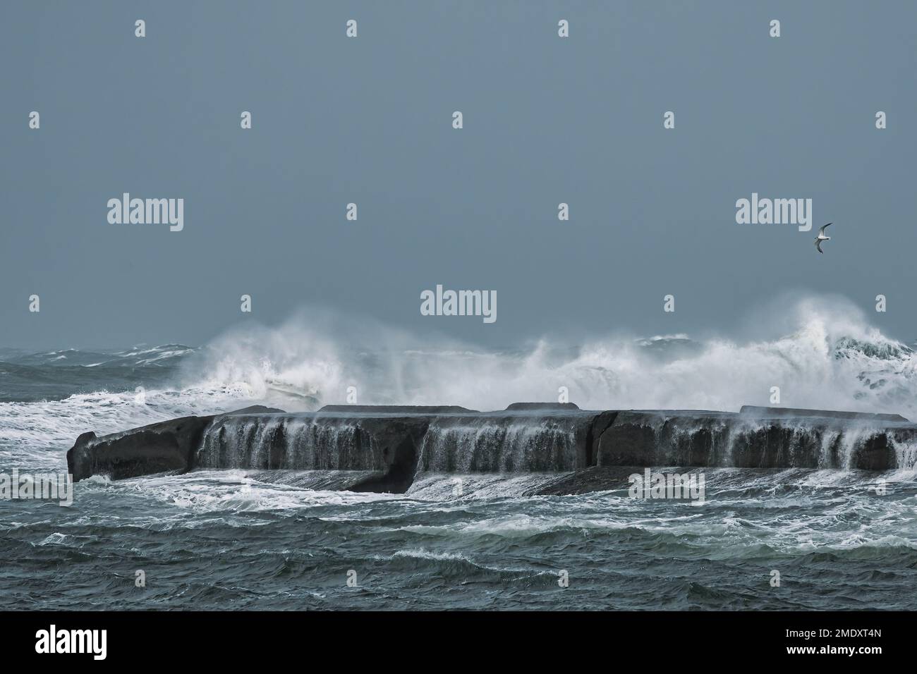 Sturmfluten erzeugen hohe Wellen, die auf einem Steg abstürzen Stockfoto