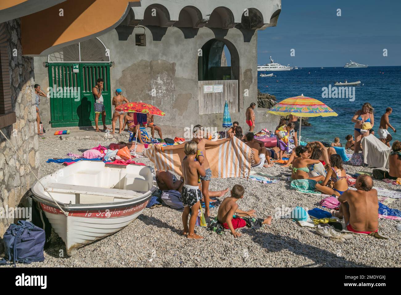 Menschen schwimmen und sonnen im Sommer am Strand von Capri, der Bucht von Neapel, dem Tyrrhenischen Meer, Italien. Stockfoto