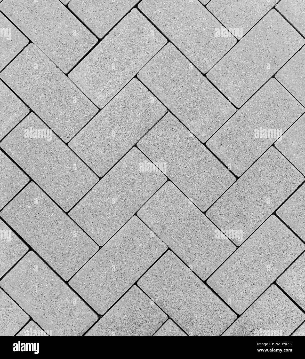 Draufsicht auf einen grauen Backsteinboden im Freien in einem Zickzackmuster Stockfoto