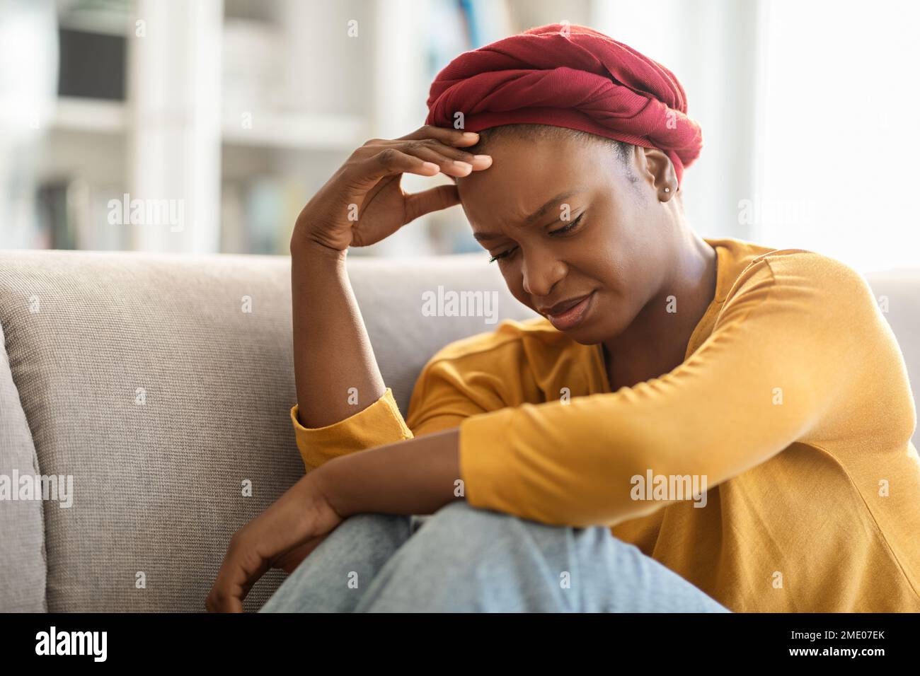 Einsame, depressive Frau, die zu Hause auf der Couch sitzt Stockfoto