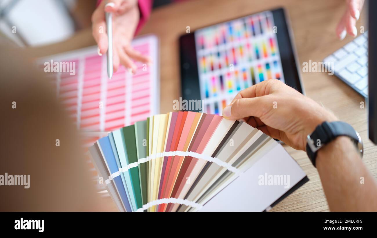 Der Kunde wählt aus einer Vielzahl von Mustern in der Nahaufnahme des Kunstateliers eine Farbe aus. Stockfoto