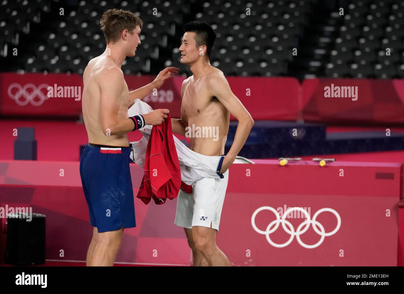 Denmark's Victor Axelsen, left, and China's Chen Long exchanges their t-shirts after Axelsen won men's singles gold medal Badminton match at the 2020 Summer Olympics, Monday, Aug. 2, 2021, in Tokyo, Japan. (AP Photo/Markus Schreiber) Stockfoto