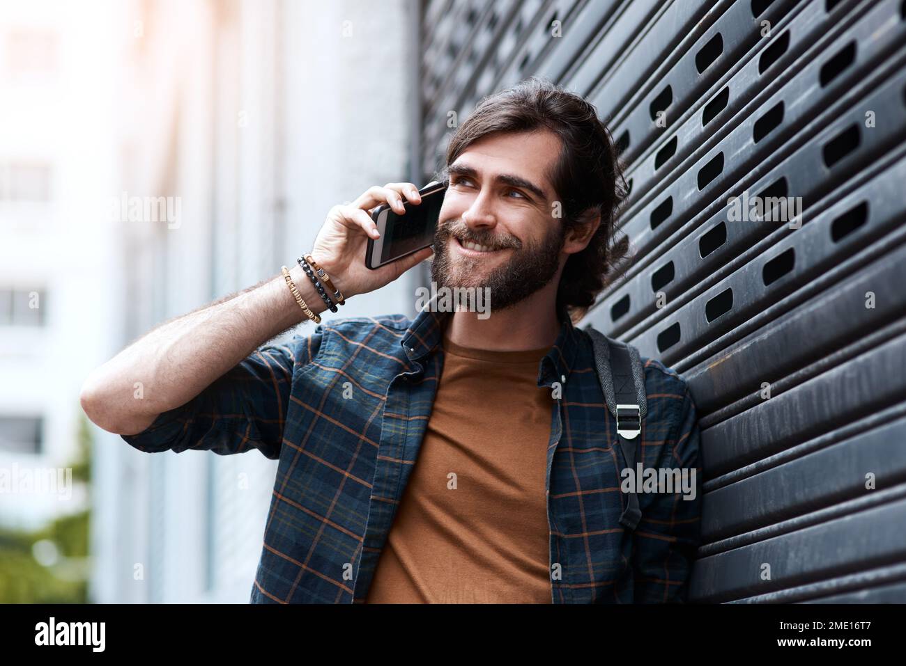 Ich hoffe, Sie haben tolle Neuigkeiten für mich. Ein gutaussehender junger Mann, der sein Handy benutzte, während er in der Stadt spazierte. Stockfoto