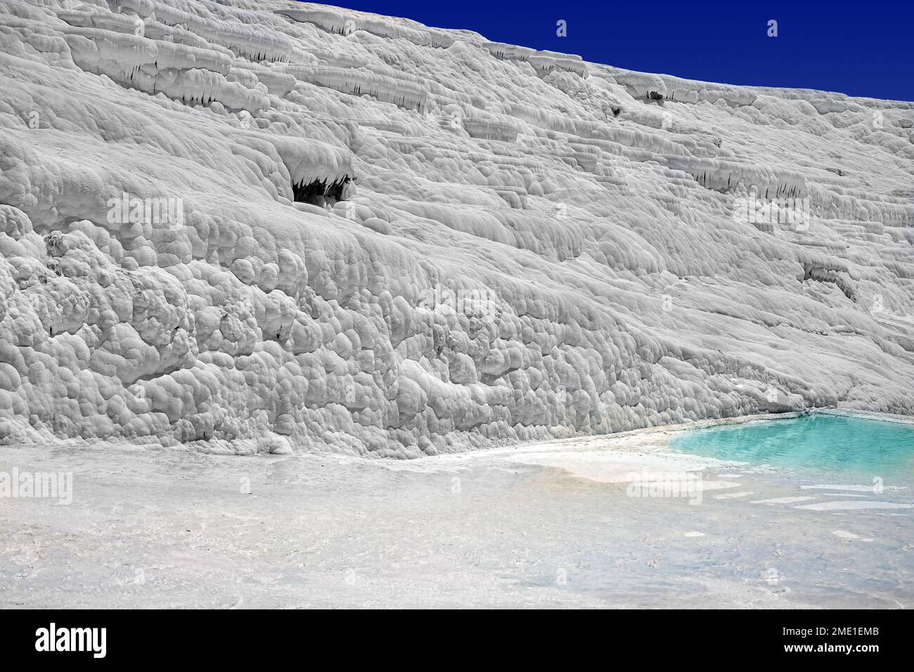 Blick auf die natürlichen Terrassen in Pamukkale an einem Sommertag. Nahaufnahme von Kalkstein und Wasser, das darüber fließt. Stockfoto